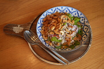 In Thailand, glass noodle salad with shrimp and crispy fried peanuts.