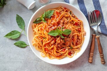 Home made Spaghetti with Tomato Sauce and minced pork in a white plate on gray cement background