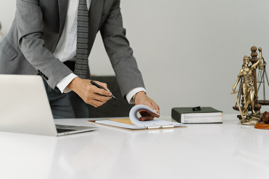 Lawyer Signing Documents:  A close-up shot of a lawyer meticulously reviewing and signing legal documents at their desk.  The image conveys professionalism, precision, and attention to detail.