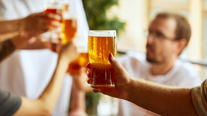 Laughter, cheers, and glasses of beer fill air as sport fans embrace thrill of game and camaraderie...