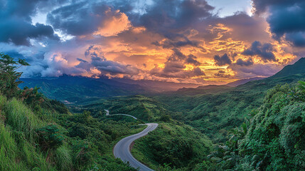 A winding asphalt highway stretching through lush green mountains under a dramatic sunset sky, with vibrant clouds, capturing the beauty of a serene road journey.
