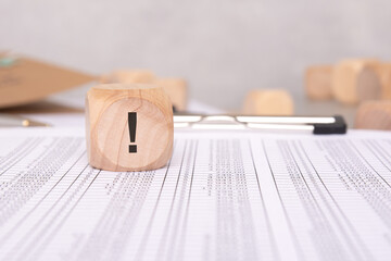 Wooden Block Featuring an Exclamation Mark Affixed to a Document for Attention and Alertness