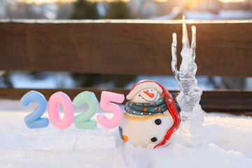 large icicle and a cute souvenir snowman, numbers 2025 as home decorations for the Christmas holidays. Postcard with a festive mood for the winter holidays