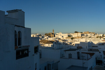 Fototapeta premium Panoramic view of the white beautiful village of Vejer de la Frontera Divino and the Salvador church in the background at sunset, Cadiz province, Andalusia, Spain