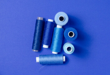 Top view of thread spools on blue background