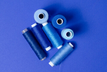 Top view of thread spools on blue background