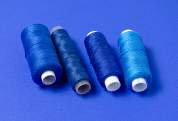 Top view of thread spools on blue background