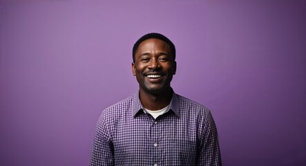 Obraz premium Smiling middleaged Black man with short hair wearing plaid shirt on plain purple background
