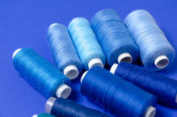 Top view of thread spools on blue background