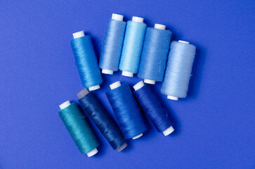 Top view of thread spools on blue background