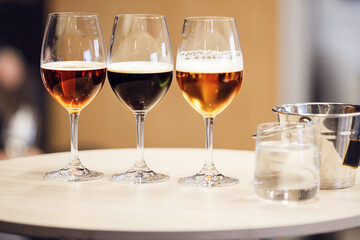 Beer Blind Tasting Prepare. Three Type of Different Beers - Lager, Unfiltered and Stout near Spitoon.