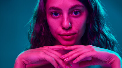 Serene yet intense look, where vibrant colors highlight facial features and smooth skin, merging...