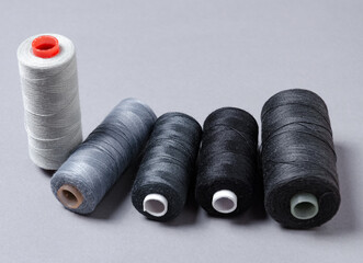 Top view of grey and black thread spools background