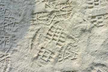 Footprints of workers' boots in the white dust covering the roads of a quarry in Vila Viçosa, Alentejo, capturing the essence of hard labor and the rugged landscape.