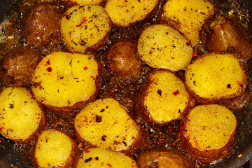 Young potatoes are fried in a frying pan