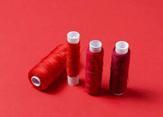 Top view of thread spools on red background