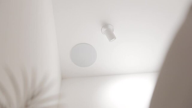 Slow motion revealing shot of a smart speaker in the ceiling of a villa
