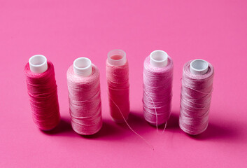 Top view of pink thread spools background