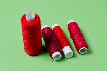 Top view of red thread spools on green background