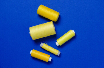 Top view of yellow thread spools on blue background