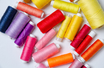 Top view of many colorful thread spools background