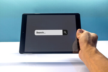 Hand holding a tablet pc to searching for information. Search engine optimization concept.