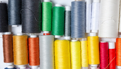 Top view of many colorful thread spools background