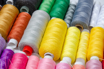 Top view of many colorful thread spools background