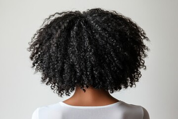 Back View of Woman with Curly Black Hair Against Minimalist White Background

