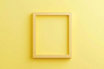 A pastel yellow background with a simple wooden frame in the center, its blankness contrasting the softness of the color. 