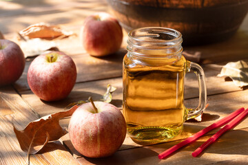 Glass of apple cider outdoors on wooden table