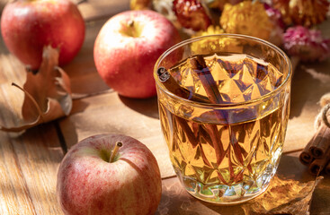 Glass of apple cider outdoors on wooden table