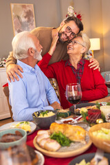 Mother hugging son while having Christmas dinner at home