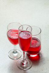 three glasses of red liquid or fresh red beer on a granite terrazzo marble table, top view