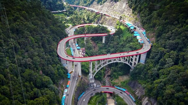 Kelok 9 or Kelok Sembilan is a winding road segment,9 sharp turns from drone, among the high hills with green and dense trees
