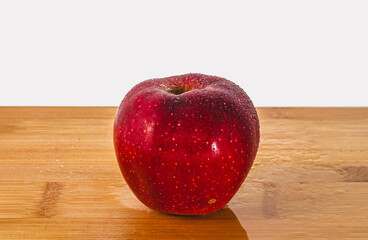 Red Apple with Water Droplets on Light Wooden Surface