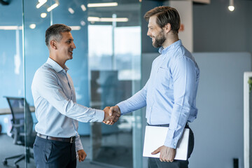 Two Businessmen Shaking Hands in a Modern Office