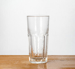 Empty glass on a wooden board with white background. Minimalist and clean design, perfect for product display or advertising