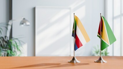 FLAGS OF COMOROS AND GUYANA ON TABLE