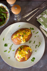 Cheesy stuffed baked potatoes topped with cheese, bacon and cream. Top view, flat lay