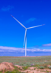 Fleet of power generators in motion. The blades of the wind farm rotate against the sky. The...