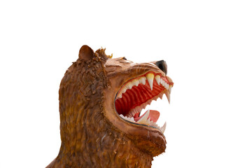 A close-up profile of a large, snarling lion statue. The lion's mouth is wide open, revealing its sharp teeth and a menacing expression. Its fur is a reddish-brown color, and its eyes are fierce.