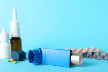 Different asthma medications on light blue background, closeup