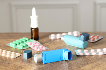Different asthma medications on wooden table indoors, closeup