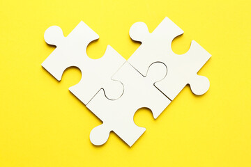Fototapeta premium White puzzle pieces on yellow background, top view