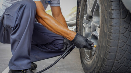 Mecánicos inspeccionando y revisando la presión de las llantas de una camioneta en un taller automotriz
