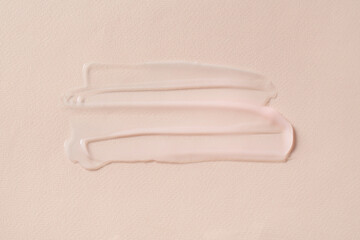 Smears of cosmetic product on beige background, top view