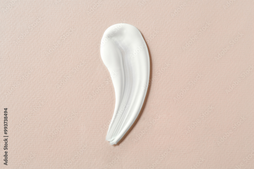 Wall mural Smear of cosmetic product on beige background, top view