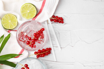 Refreshing water with red currants in glass on light table, space for text