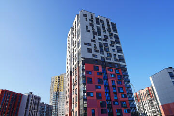 Skyscraper facade. Modern High rise residential facade. Windows of Skyscraper. Modern colourful building. Architecture building exterior facade window house block. High Rise house against blue sky.